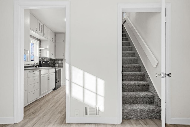 1012 4th St, Minot, ND 58701 - stairway featuring visible vents, wood finished floors, and baseboards