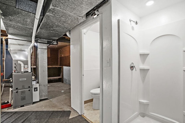 interior space featuring concrete floors, heating unit, and toilet