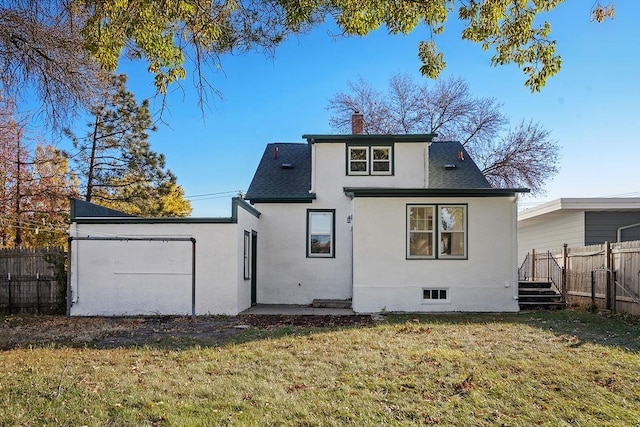 1012 4th St, Minot, ND 58701 - back of property featuring a lawn, a chimney, stucco siding, and fence
