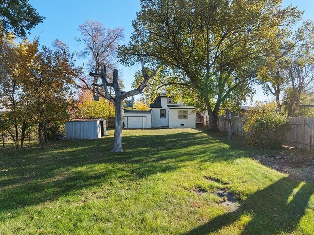 1012 4th St, Minot, ND 58701 - view of yard with an outdoor structure, fence, and a shed