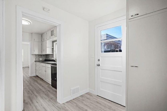 1012 4th St, Minot, ND 58701 - entryway with light wood-type flooring, baseboards, visible vents, and a sink