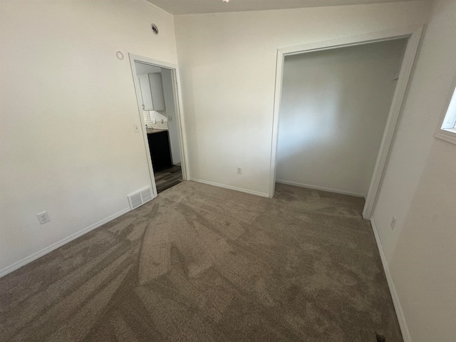 carpeted empty room featuring lofted ceiling