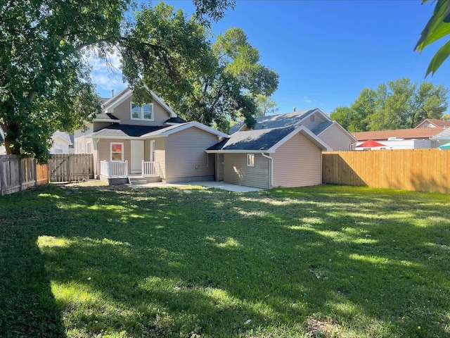 back of property with a patio area and a lawn