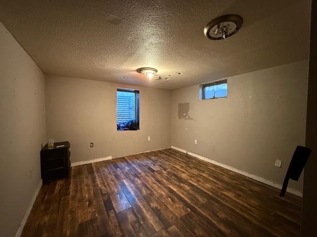 spare room featuring dark hardwood / wood-style flooring and a textured ceiling