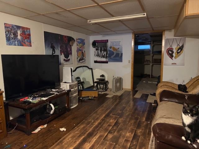 living room with dark wood-type flooring and a paneled ceiling