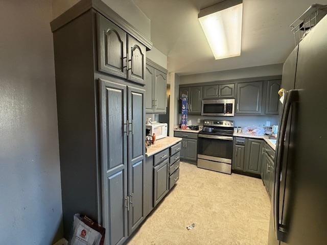 kitchen with gray cabinetry and stainless steel appliances