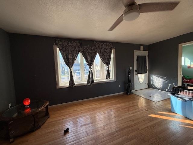 foyer entrance with wood-type flooring, a textured ceiling, and ceiling fan