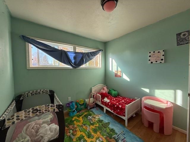 bedroom with multiple windows and wood-type flooring