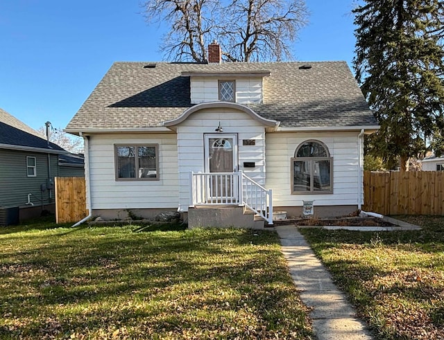 bungalow-style home with roof with shingles, fence, a chimney, and a front lawn