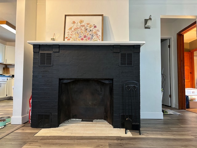 details with visible vents, a fireplace, and wood finished floors