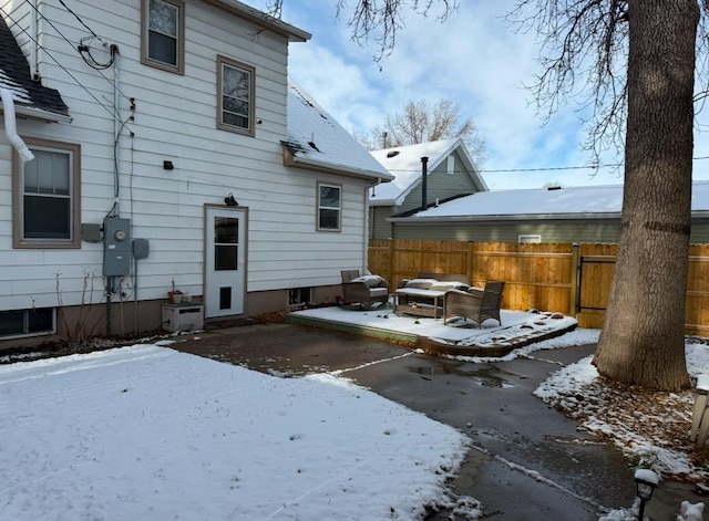 snow covered property featuring fence and a patio