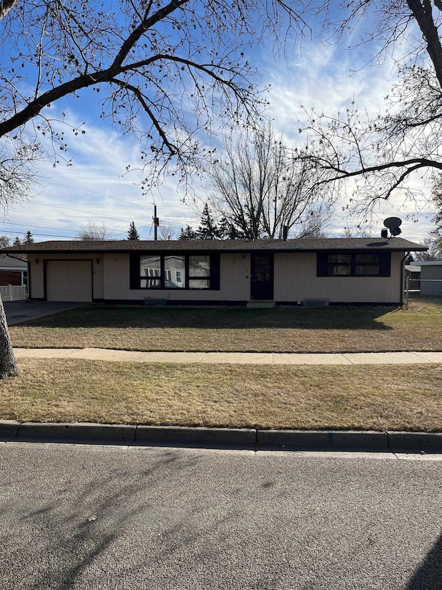 view of front of home with a front yard and a garage