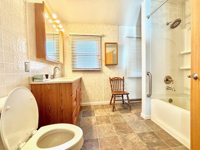 full bathroom featuring tile walls, tiled shower / bath, toilet, and vanity