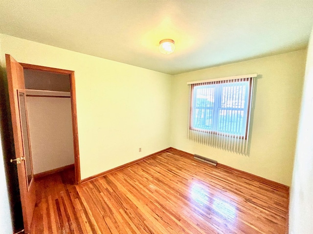 unfurnished bedroom featuring a closet and hardwood / wood-style floors