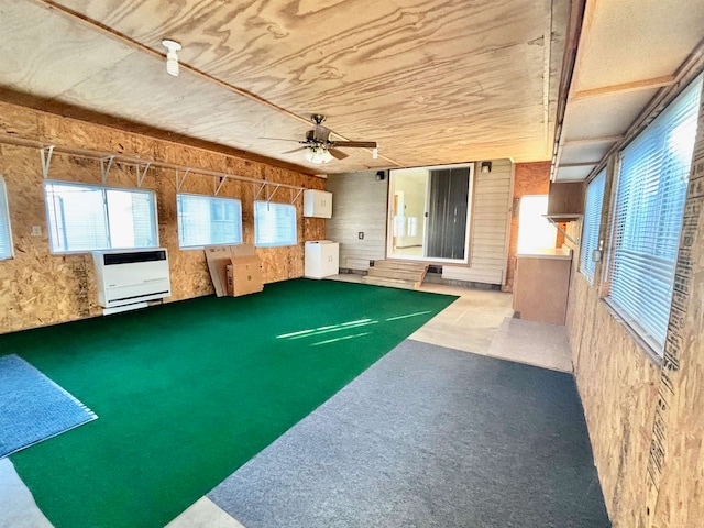 recreation room featuring light colored carpet, ceiling fan, and heating unit