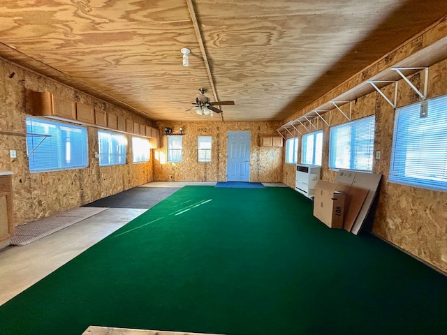 unfurnished sunroom featuring ceiling fan and heating unit