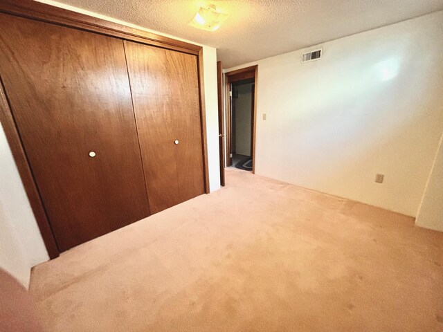 6 4th Ave, Towner, ND 58788 - unfurnished bedroom featuring a closet, a textured ceiling, and carpet flooring