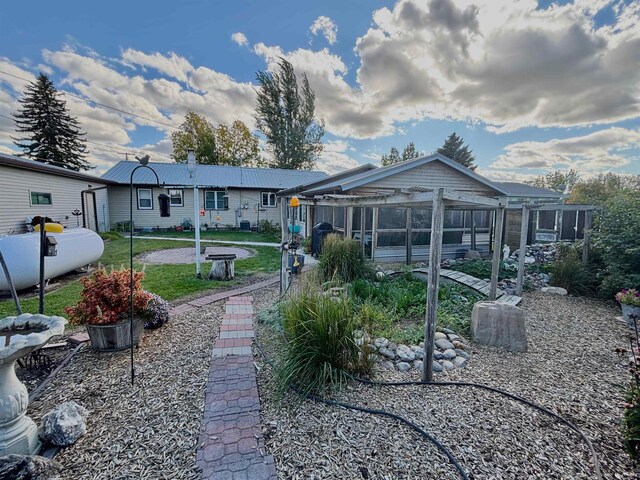 6 4th Ave, Towner, ND 58788 - rear view of house with a sunroom, a yard, and metal roof