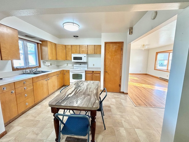 kitchen with white appliances, sink, and light hardwood / wood-style flooring