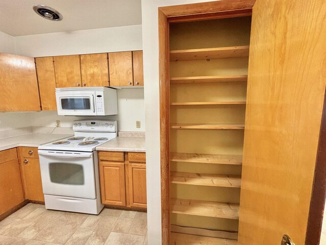 6 4th Ave, Towner, ND 58788 - kitchen featuring white appliances, light countertops, and brown cabinetry