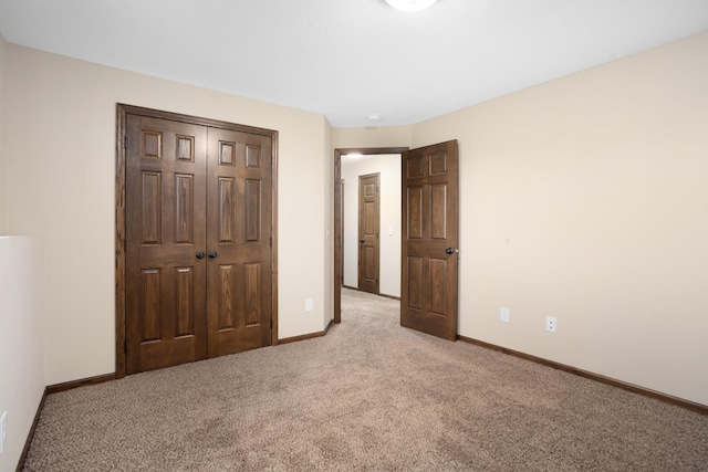 unfurnished bedroom featuring light colored carpet and a closet