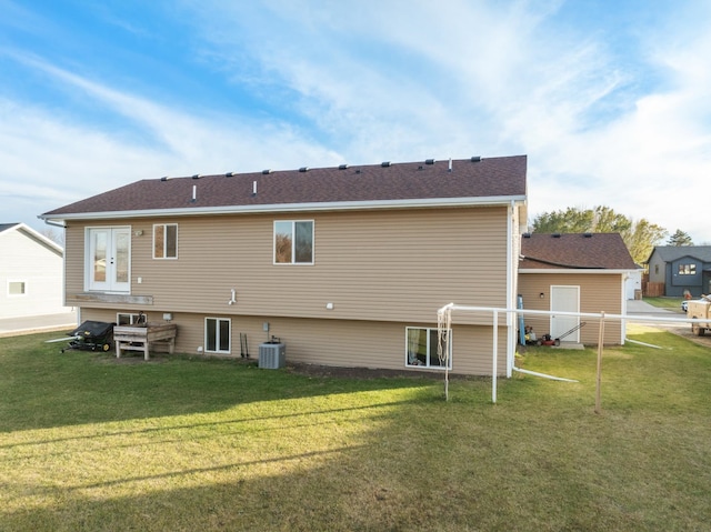 back of property featuring central air condition unit and a yard