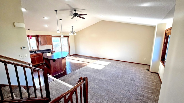 kitchen featuring lofted ceiling, sink, hanging light fixtures, dark hardwood / wood-style floors, and a kitchen island