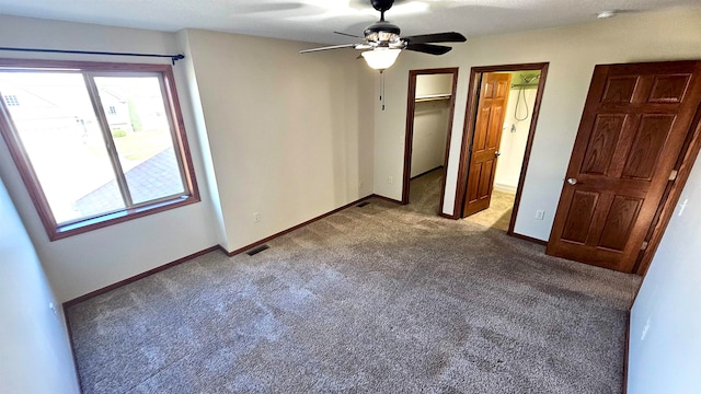 unfurnished bedroom featuring multiple windows, a spacious closet, and light carpet