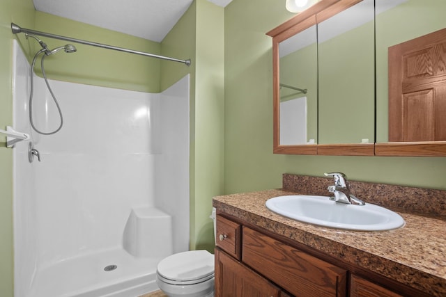 bathroom with a shower, vanity, and toilet