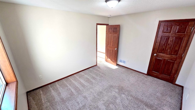 unfurnished bedroom featuring carpet floors and a textured ceiling