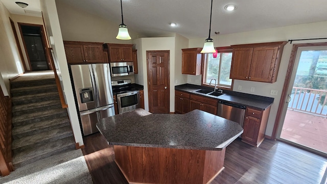 kitchen with sink, dark hardwood / wood-style flooring, decorative light fixtures, a kitchen island, and appliances with stainless steel finishes