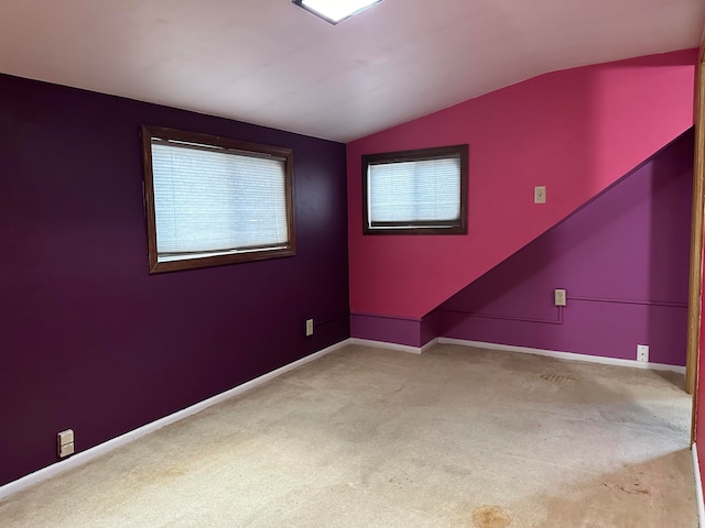 unfurnished room with light colored carpet and lofted ceiling