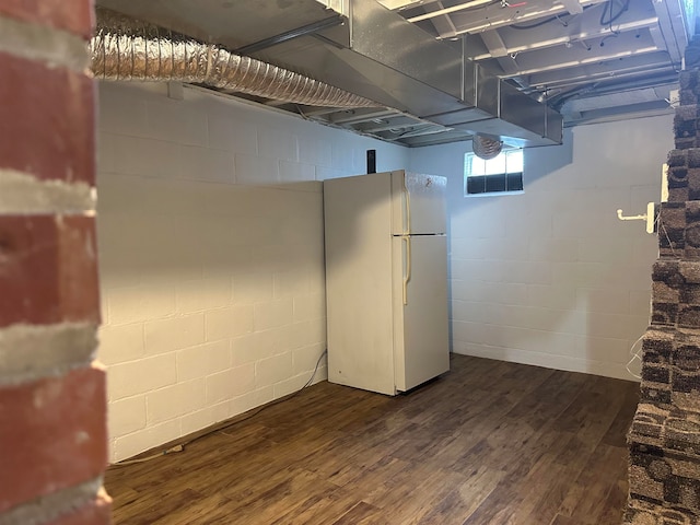 basement featuring dark hardwood / wood-style floors and white refrigerator