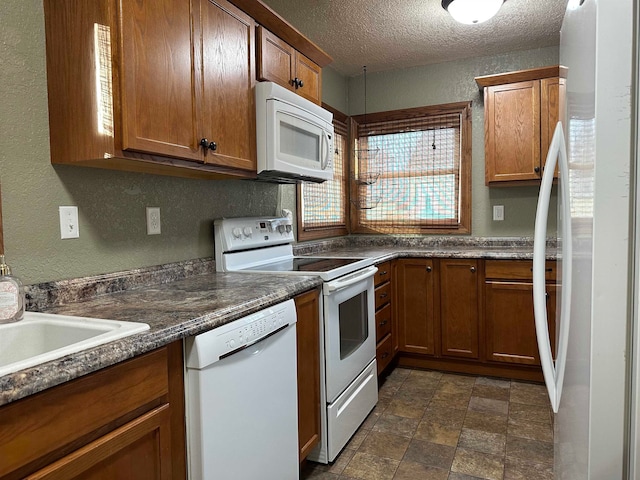 kitchen featuring a textured ceiling and white appliances