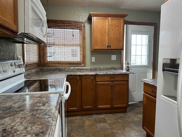 kitchen with a textured ceiling and white appliances