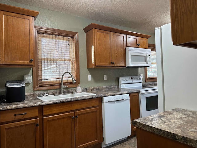 kitchen featuring a textured ceiling, sink, and white appliances