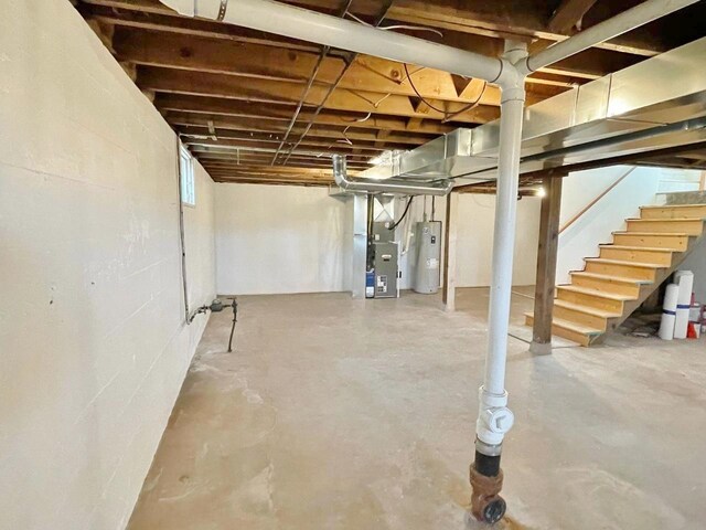 basement featuring heating unit and electric water heater