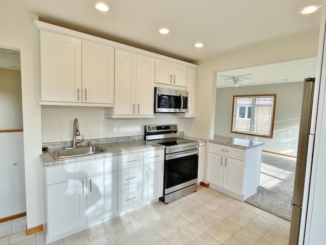 kitchen with white cabinets, appliances with stainless steel finishes, ceiling fan, and sink