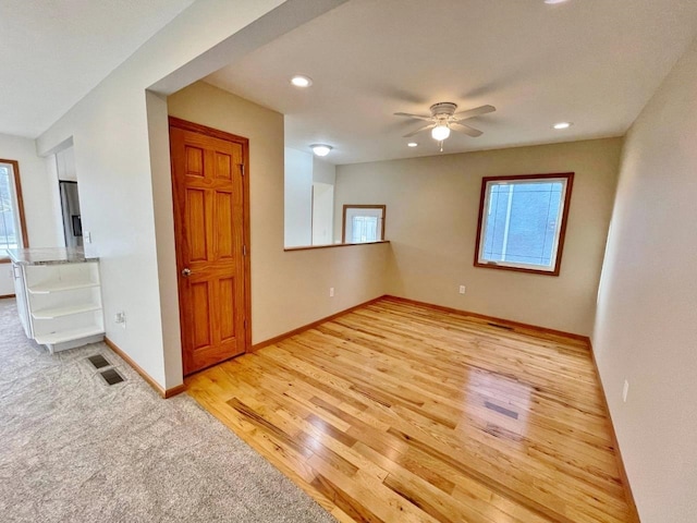 unfurnished room with ceiling fan and light wood-type flooring