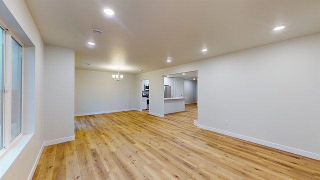 interior space featuring a notable chandelier and light wood-type flooring