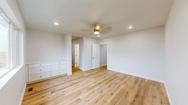 unfurnished bedroom featuring multiple windows, ceiling fan, and light hardwood / wood-style flooring