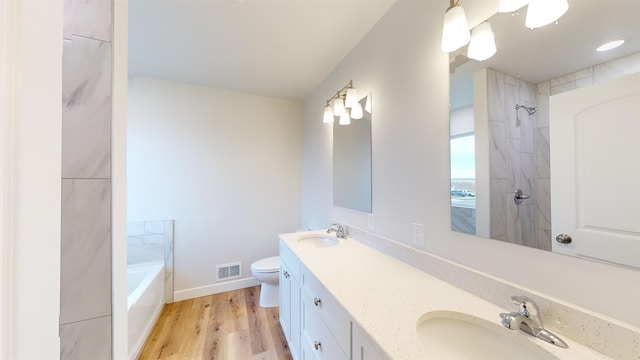 full bathroom with hardwood / wood-style floors, vanity, toilet, and independent shower and bath