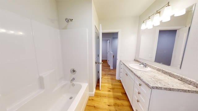 bathroom with bathing tub / shower combination, vanity, and wood-type flooring