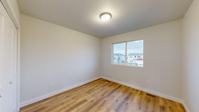 unfurnished bedroom with a closet and light wood-type flooring