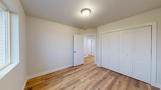 unfurnished bedroom with a closet and light hardwood / wood-style flooring