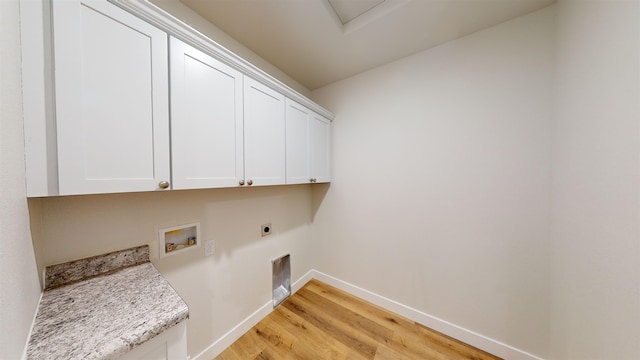 laundry room with electric dryer hookup, hookup for a washing machine, cabinets, and light wood-type flooring