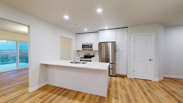 kitchen with white cabinetry, sink, light wood-type flooring, and appliances with stainless steel finishes