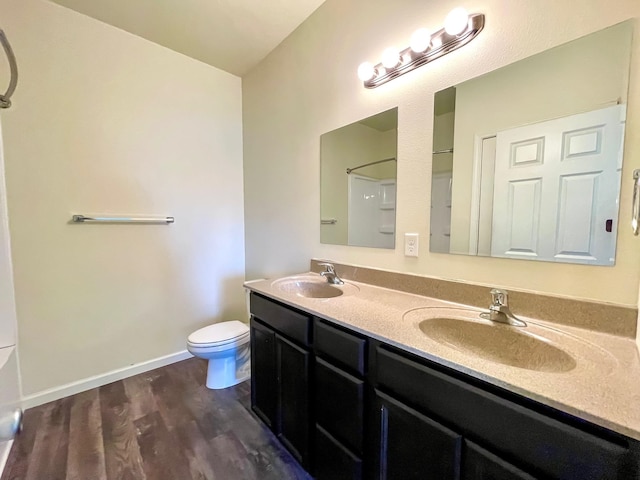 bathroom featuring hardwood / wood-style floors, vanity, toilet, and walk in shower