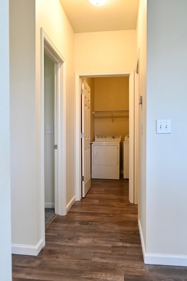 corridor with independent washer and dryer and dark hardwood / wood-style floors