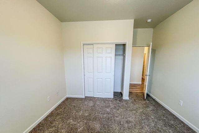 unfurnished bedroom featuring dark colored carpet and a closet